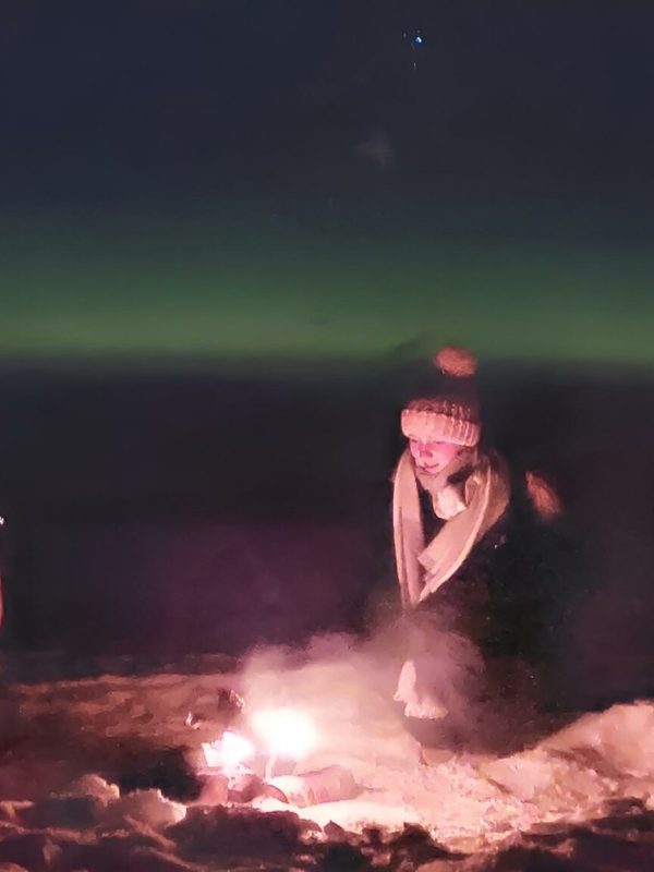 Feu de camp avec enfants et aurores boréales